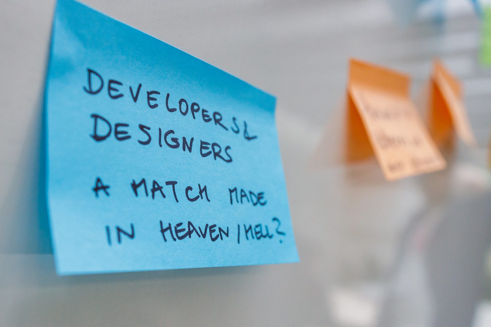 A sticky note that reads 'developers and designers, a match made in heaven/hell? A sticky note that reads ‘developers and designers, a match made in heaven/hell?